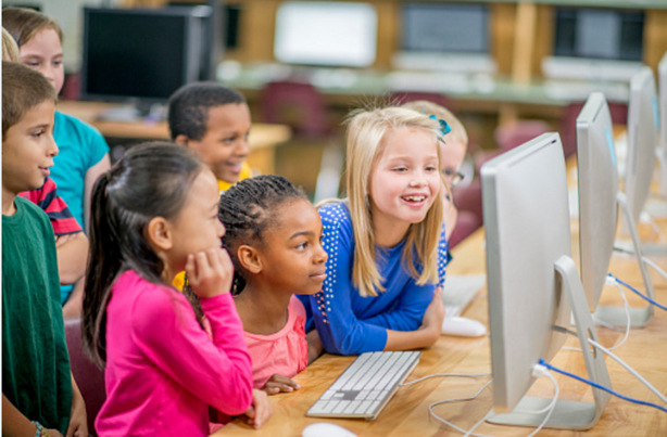 Group of children using a computer, looking at the display